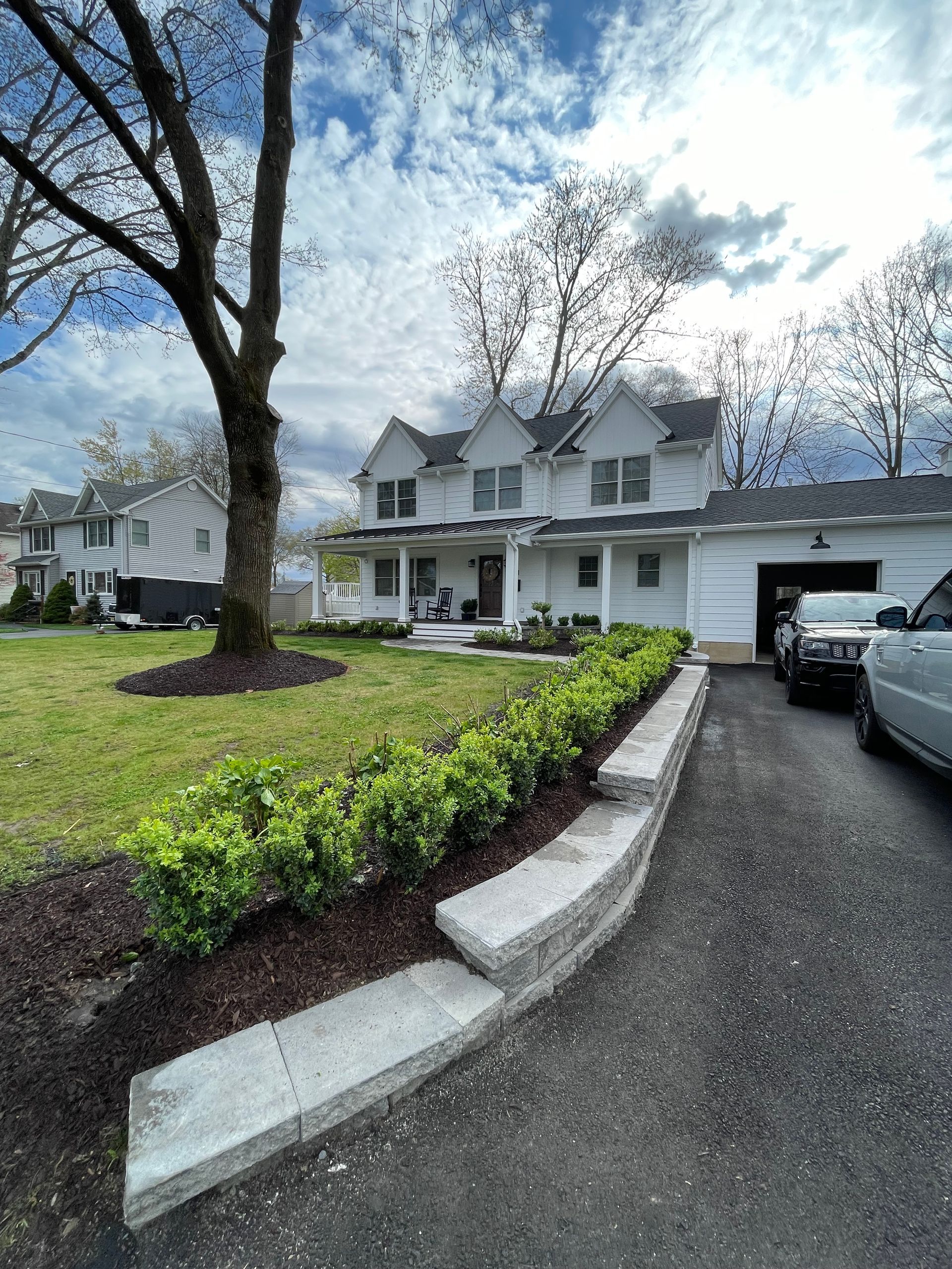 A white house with cars parked in front of it.