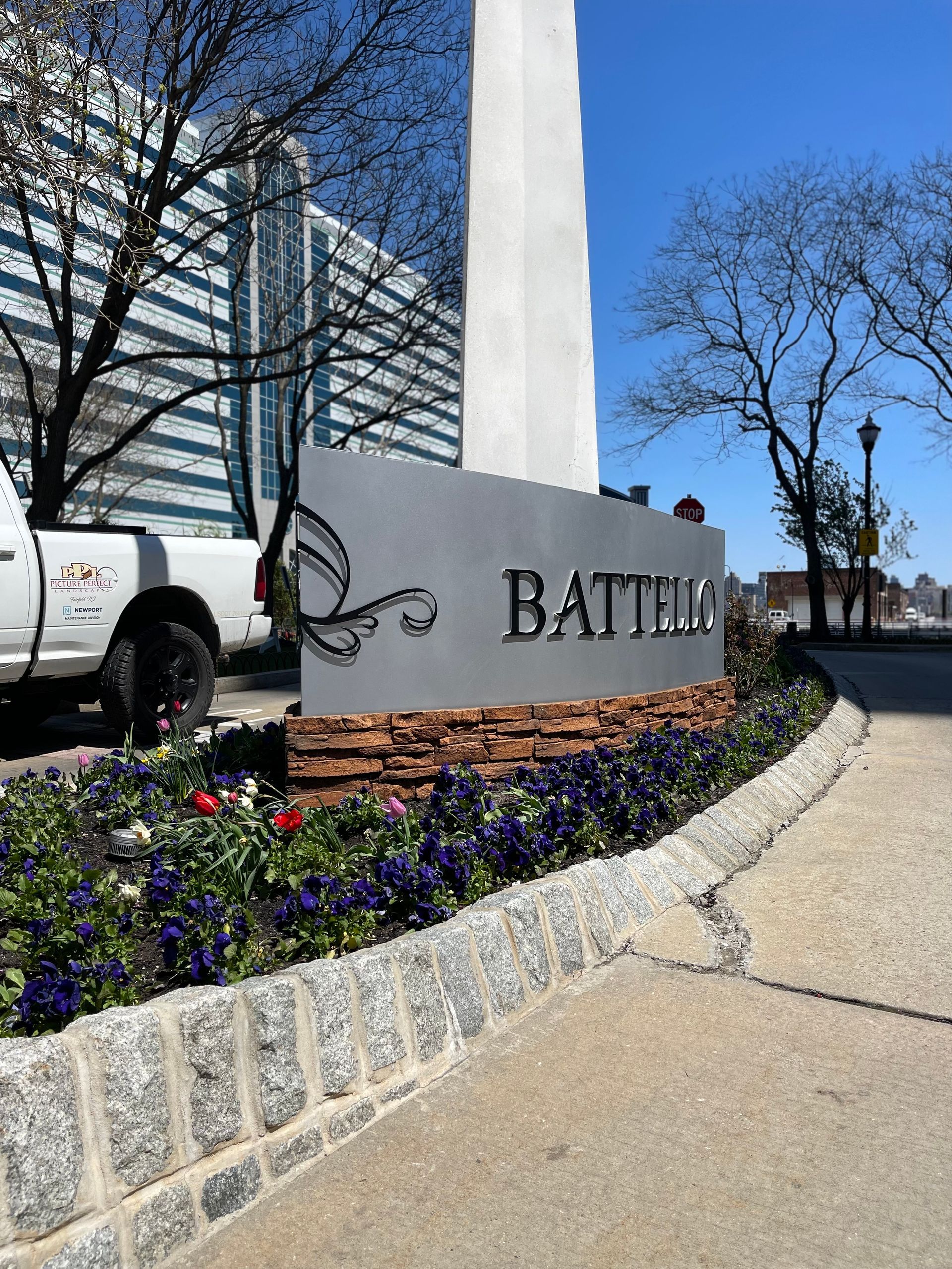 A white truck is parked in front of a sign that says battell