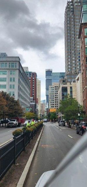A city street with a lot of tall buildings on a cloudy day.