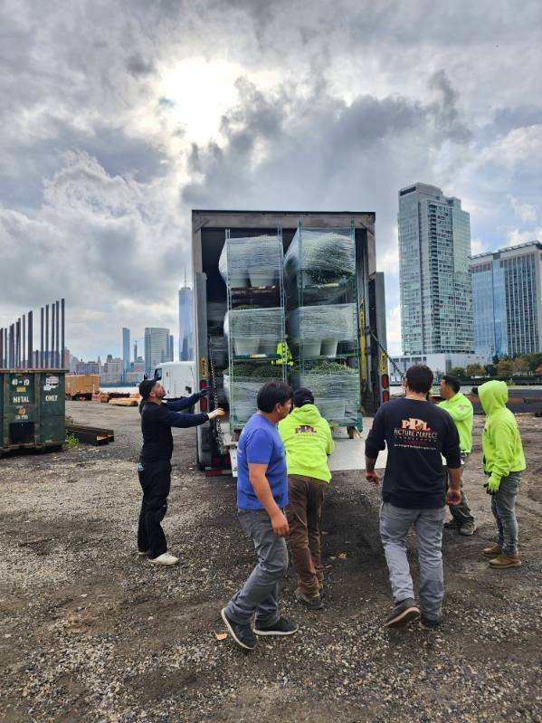 A group of people are standing in front of a truck.