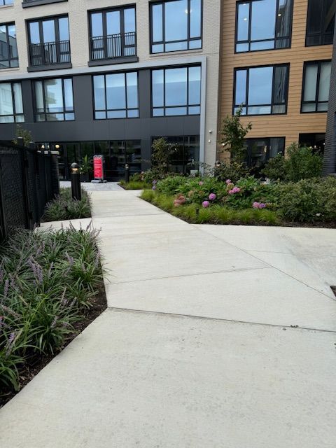 A walkway leading to a building with lots of windows