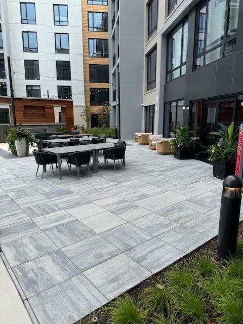 A patio with tables and chairs in front of a building.