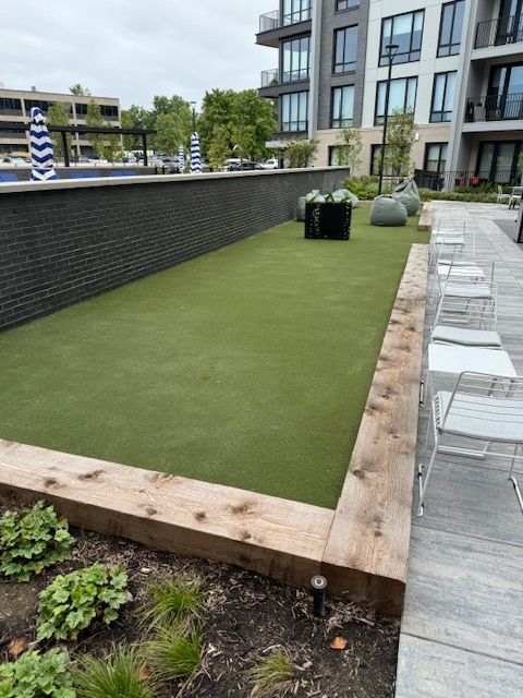 A lawn with chairs and a brick wall in the background