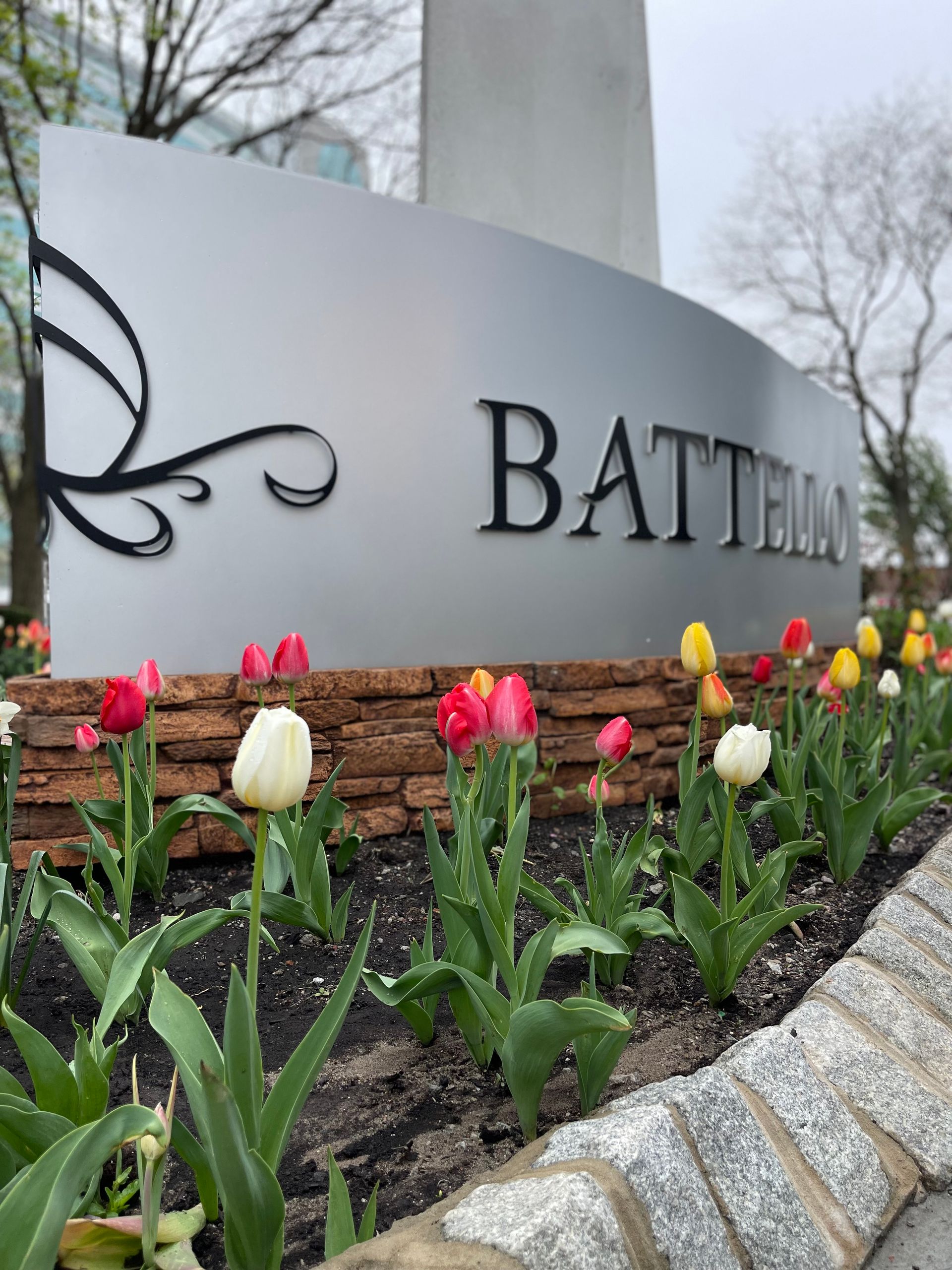 A sign that says battell is surrounded by flowers