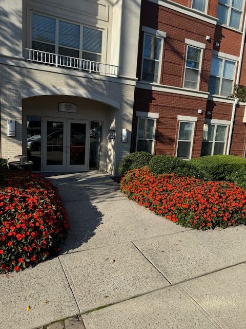 A building with a lot of windows and flowers in front of it