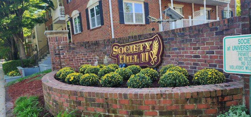 A brick wall with a sign that says Society Hall on it.