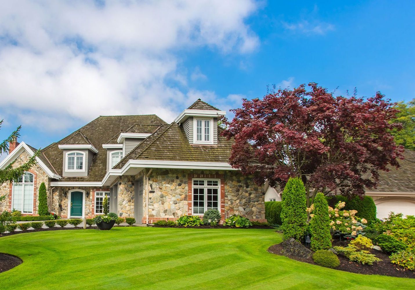 A large house with a lush green lawn in front of it.