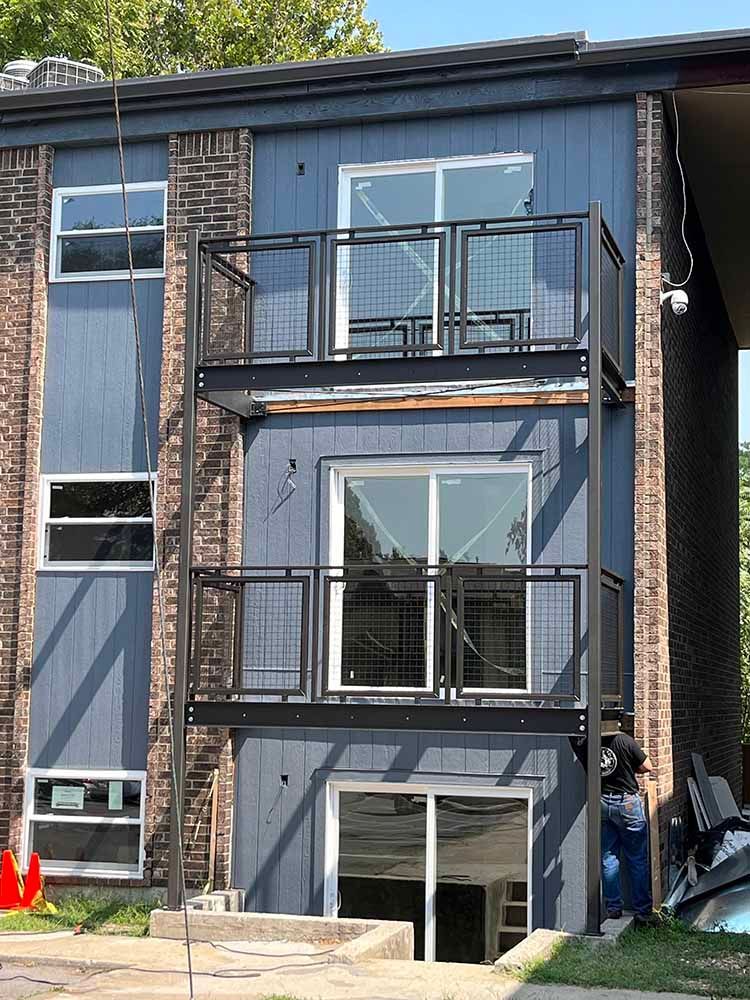 A blue house with a balcony on the second floor.