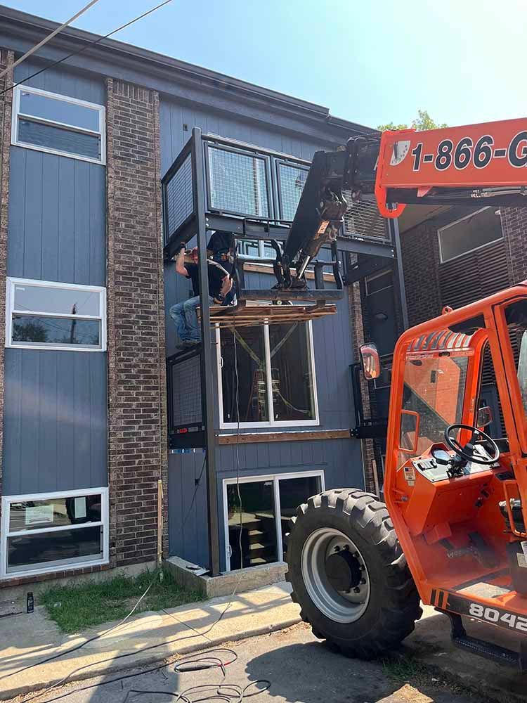 A forklift is being used to lift a ladder into a building.