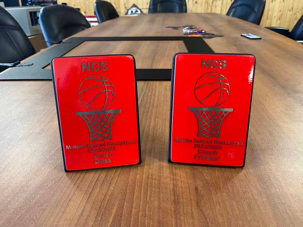 Two red cards with a basketball on them are sitting on a wooden table.