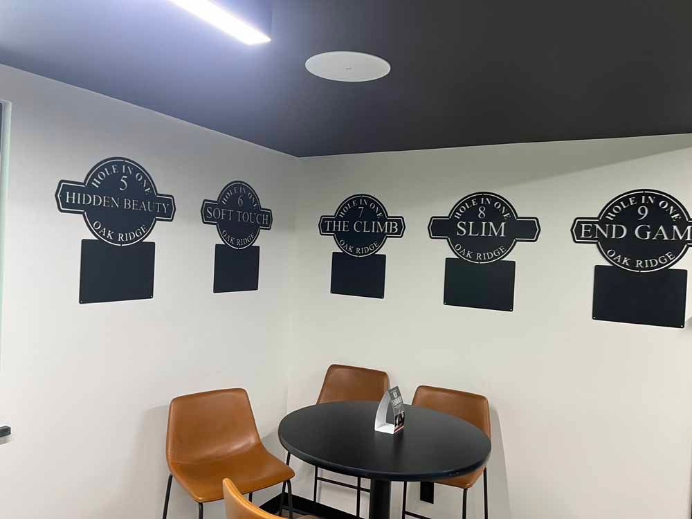A room with a table and chairs and chalkboard signs on the wall.
