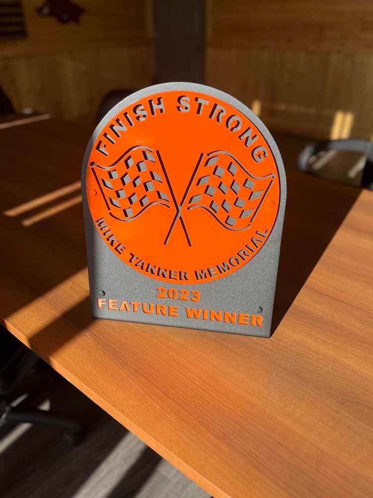 A plaque that says finish strong is sitting on a wooden table.