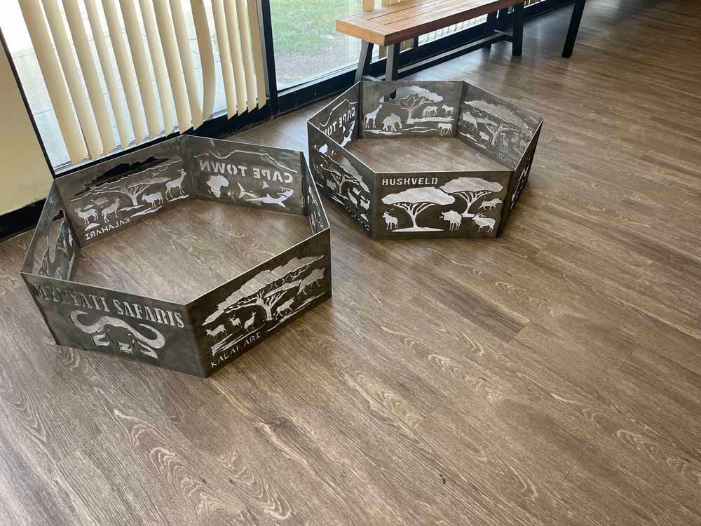 Two fire pits are sitting on a wooden floor in a room.