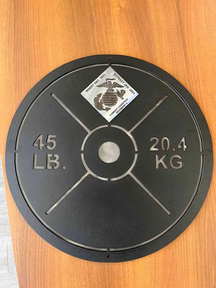 A 45 lb weight plate is sitting on a wooden table