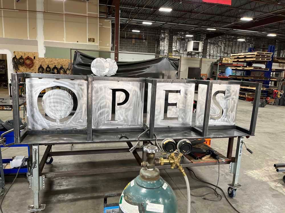 A metal sign is being built in a factory.