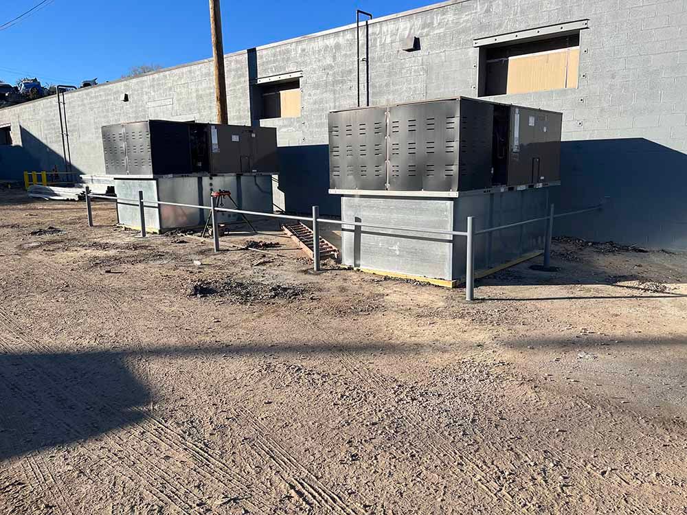 A row of air conditioners are sitting in front of a building.