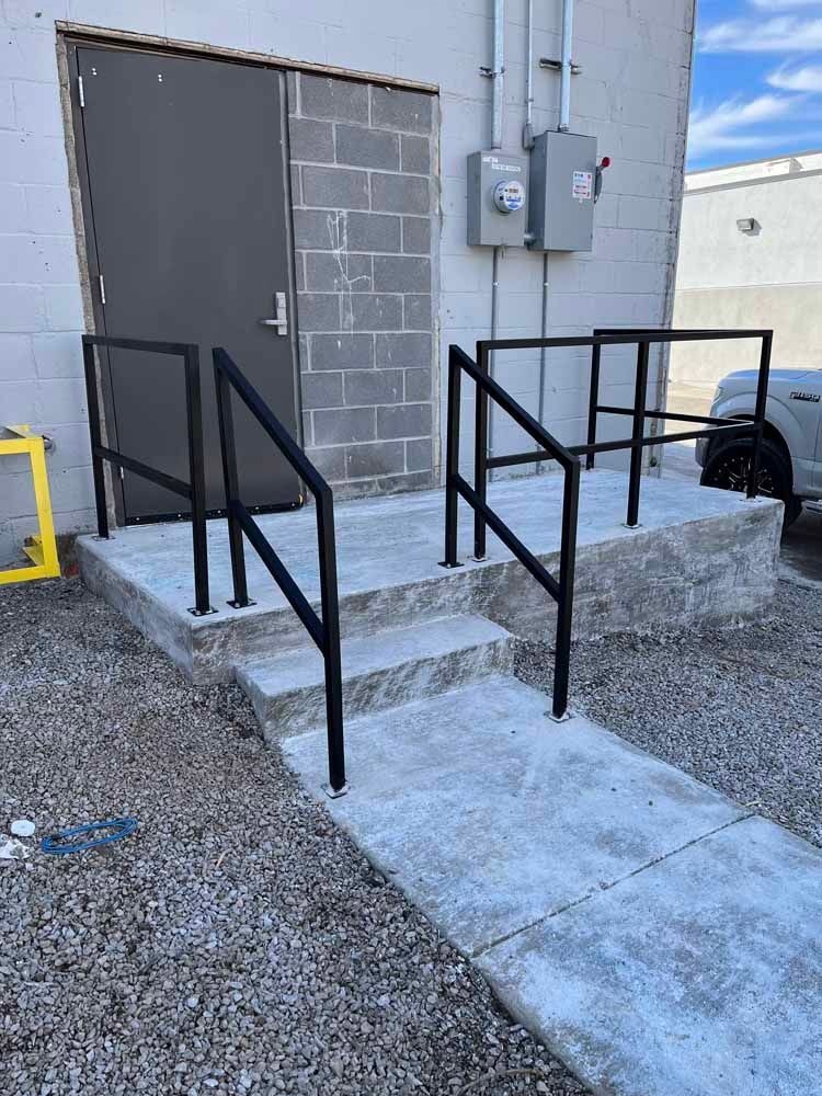 A staircase with a railing and a door in the background.