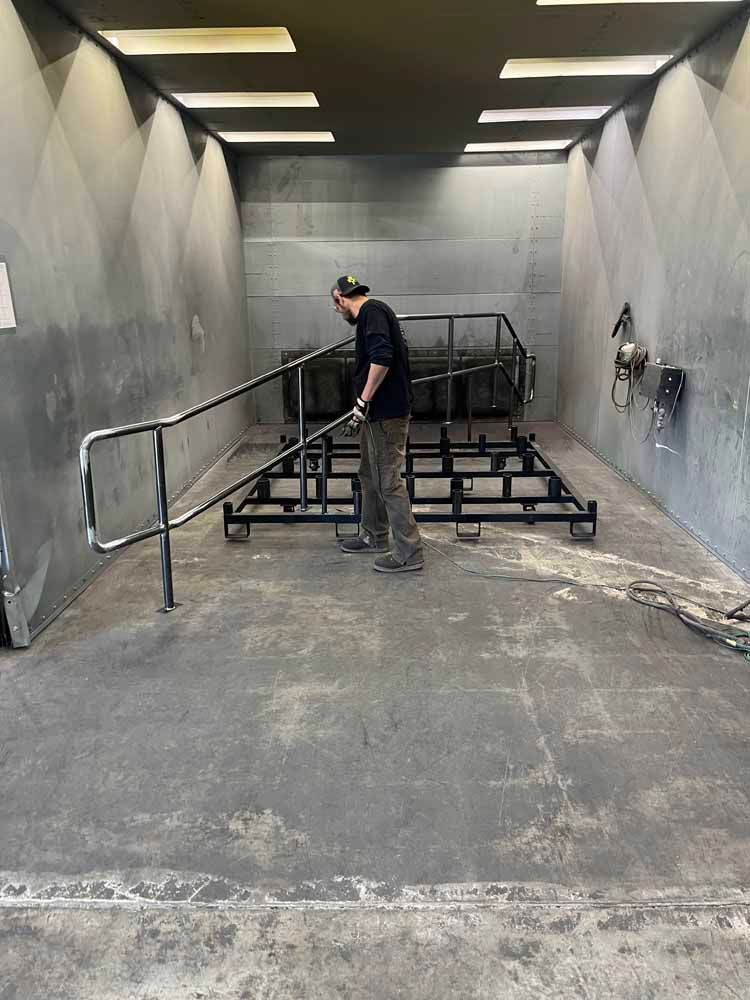 A man is standing in a room with a railing.