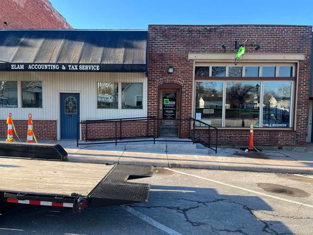 A tow truck is parked in front of a brick building.
