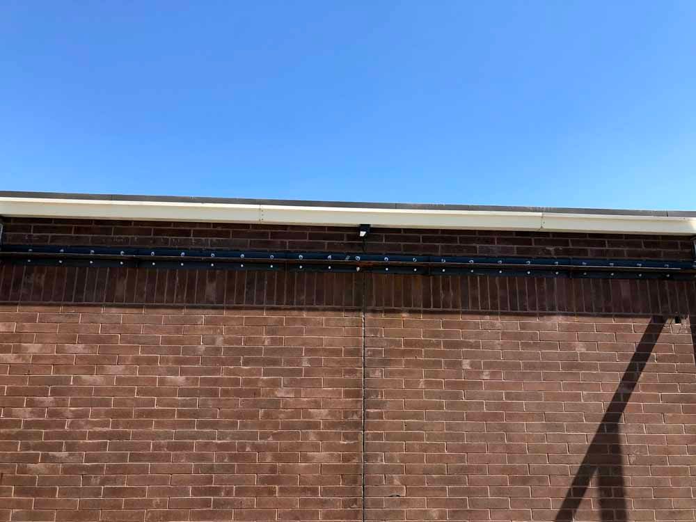 A brick wall with a blue sky in the background.