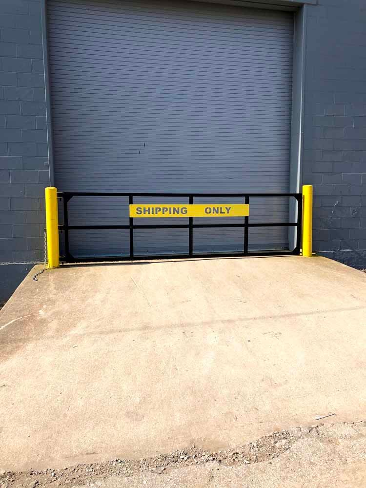 A shipping only gate is in front of a warehouse door.