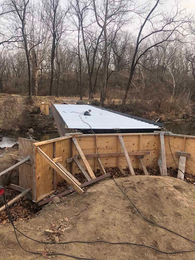 A bridge is being built over a river in the middle of a forest.