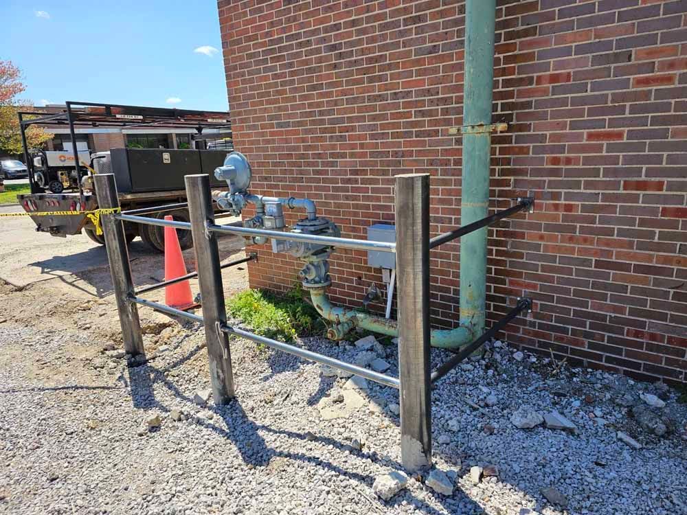 A fence is being built in front of a brick building.