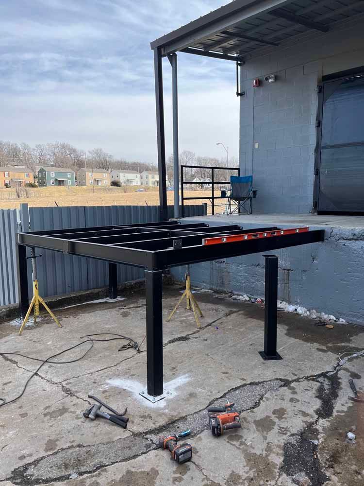 A metal platform is being built on the side of a building.