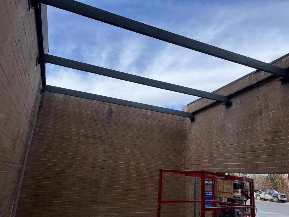 A metal structure is being built on top of a brick building.