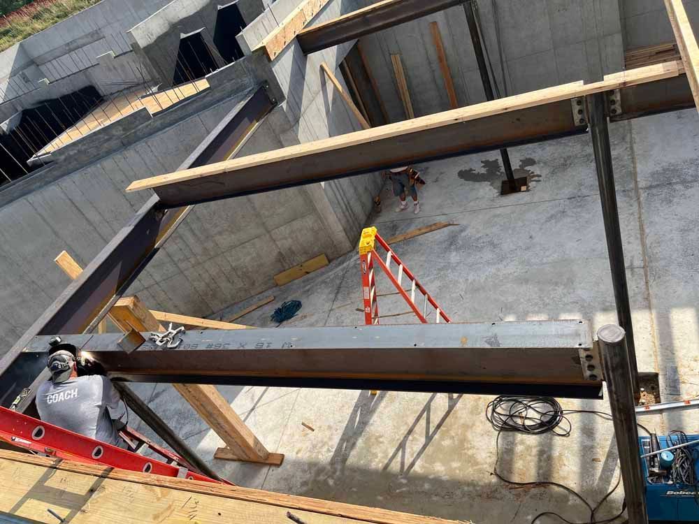 A ladder is sitting on the ground in a building under construction.