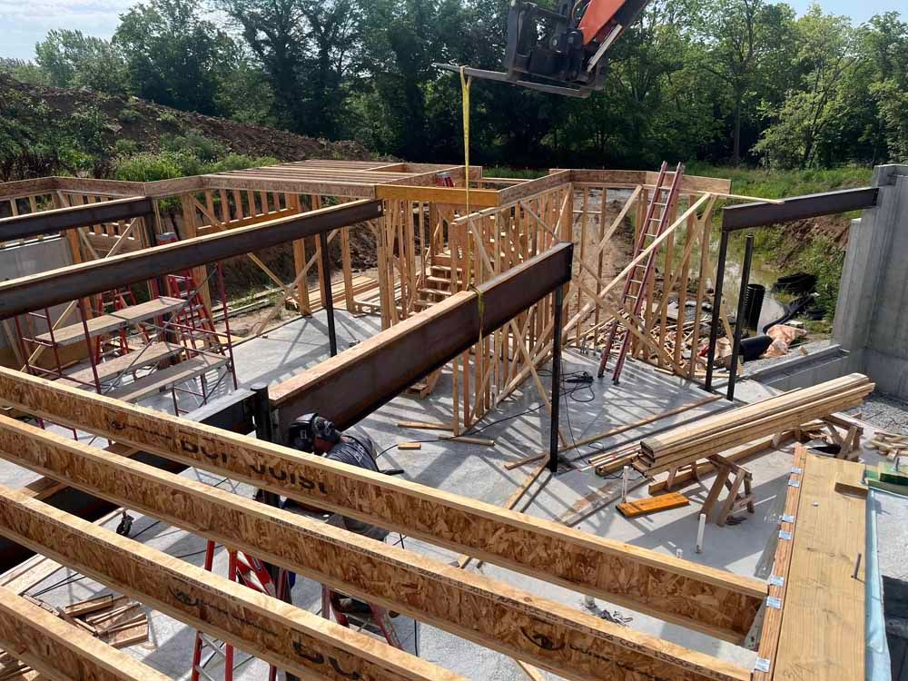 A construction site with a lot of wooden beams and a crane.
