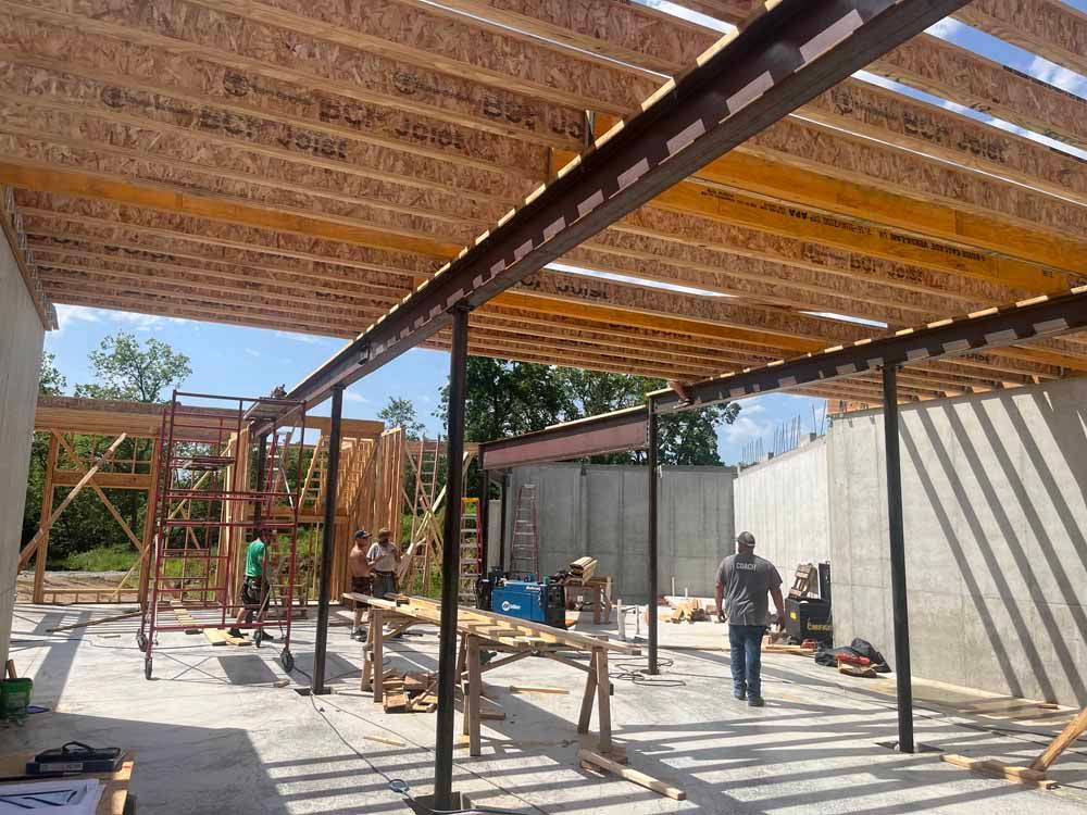 A man is walking through a building under construction.