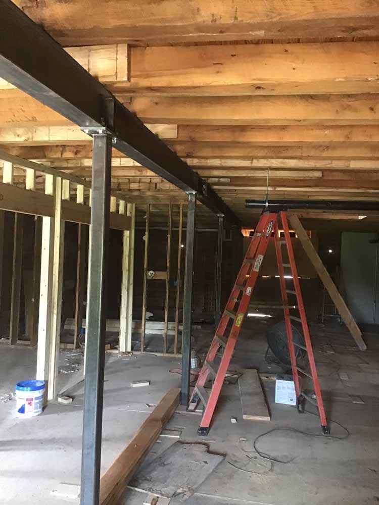 A ladder is sitting in the middle of a room under construction.