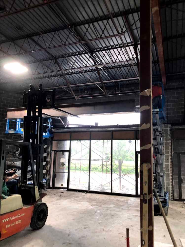 A forklift is parked inside of a building under construction.