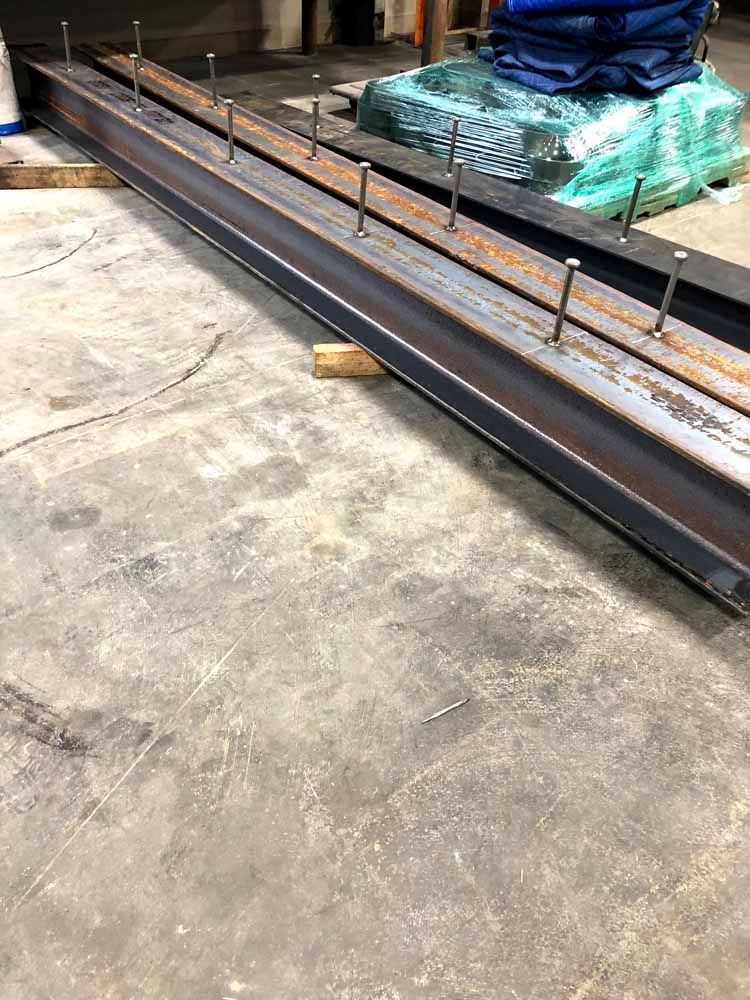 A large metal beam is sitting on top of a concrete floor.