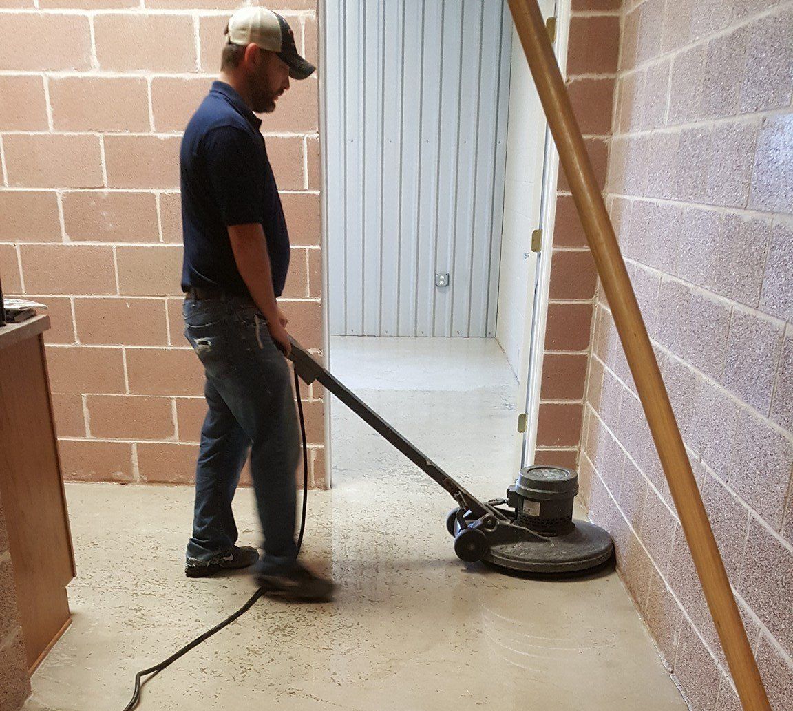 A man is using a machine to clean a concrete floor