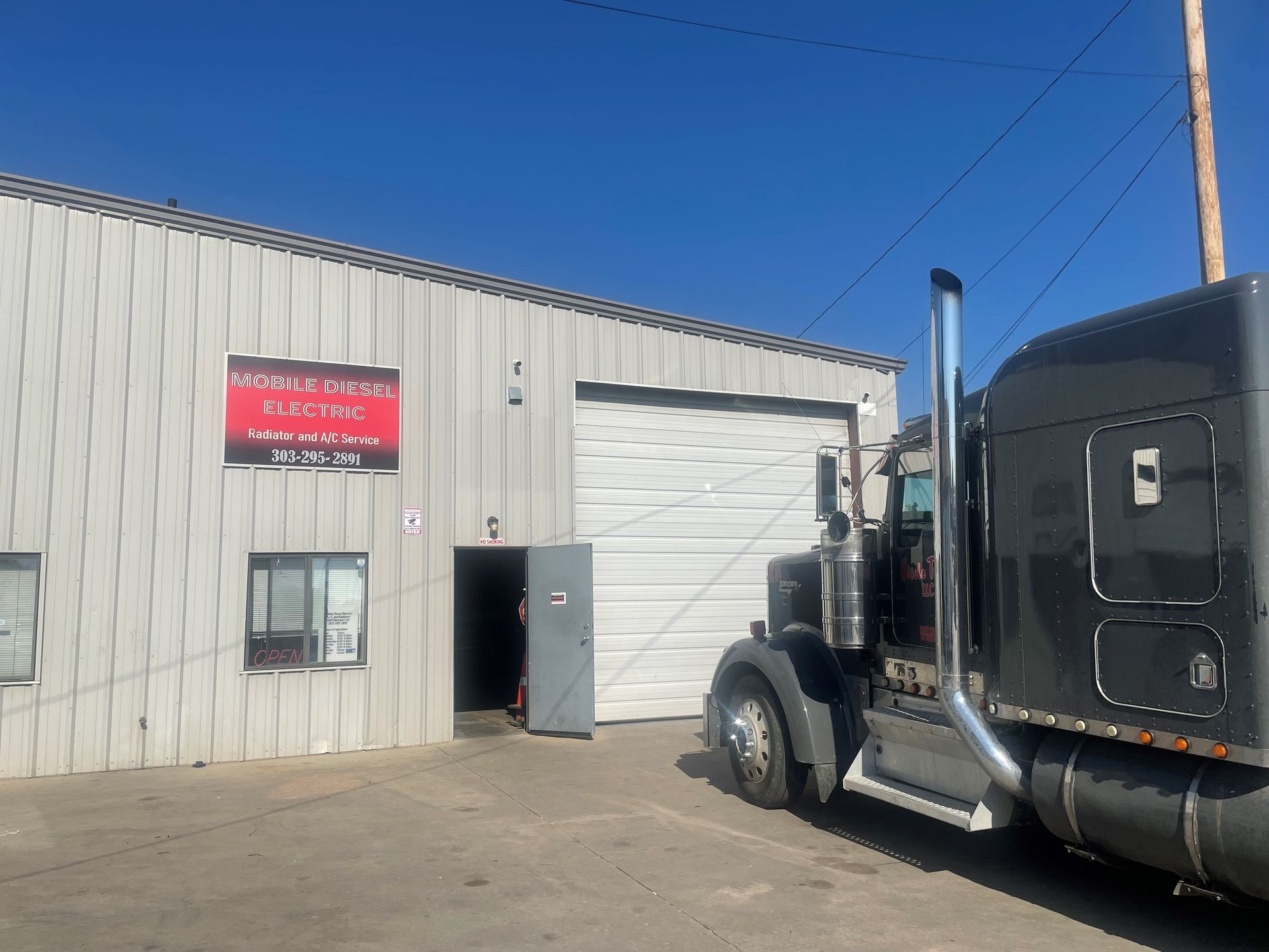 A semi truck is parked in front of a building.