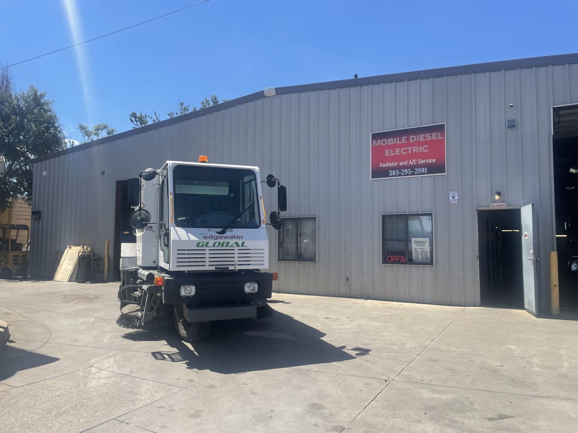 A white truck is parked in front of a building