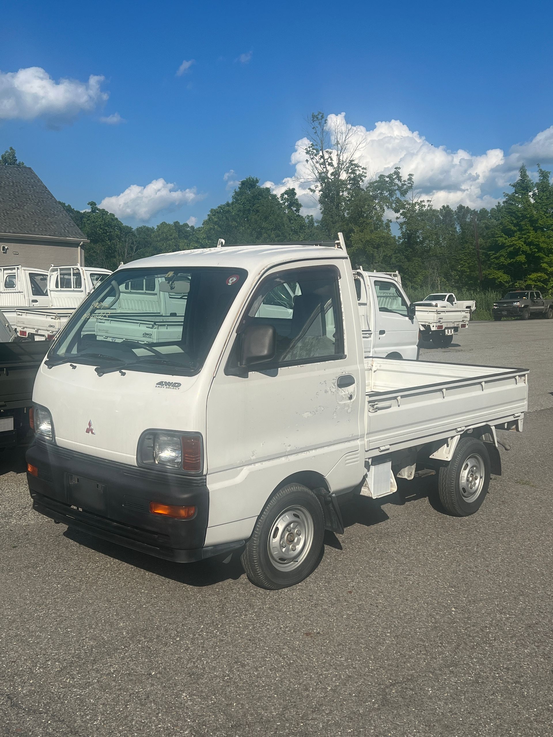 A white dump truck is parked in a gravel lot