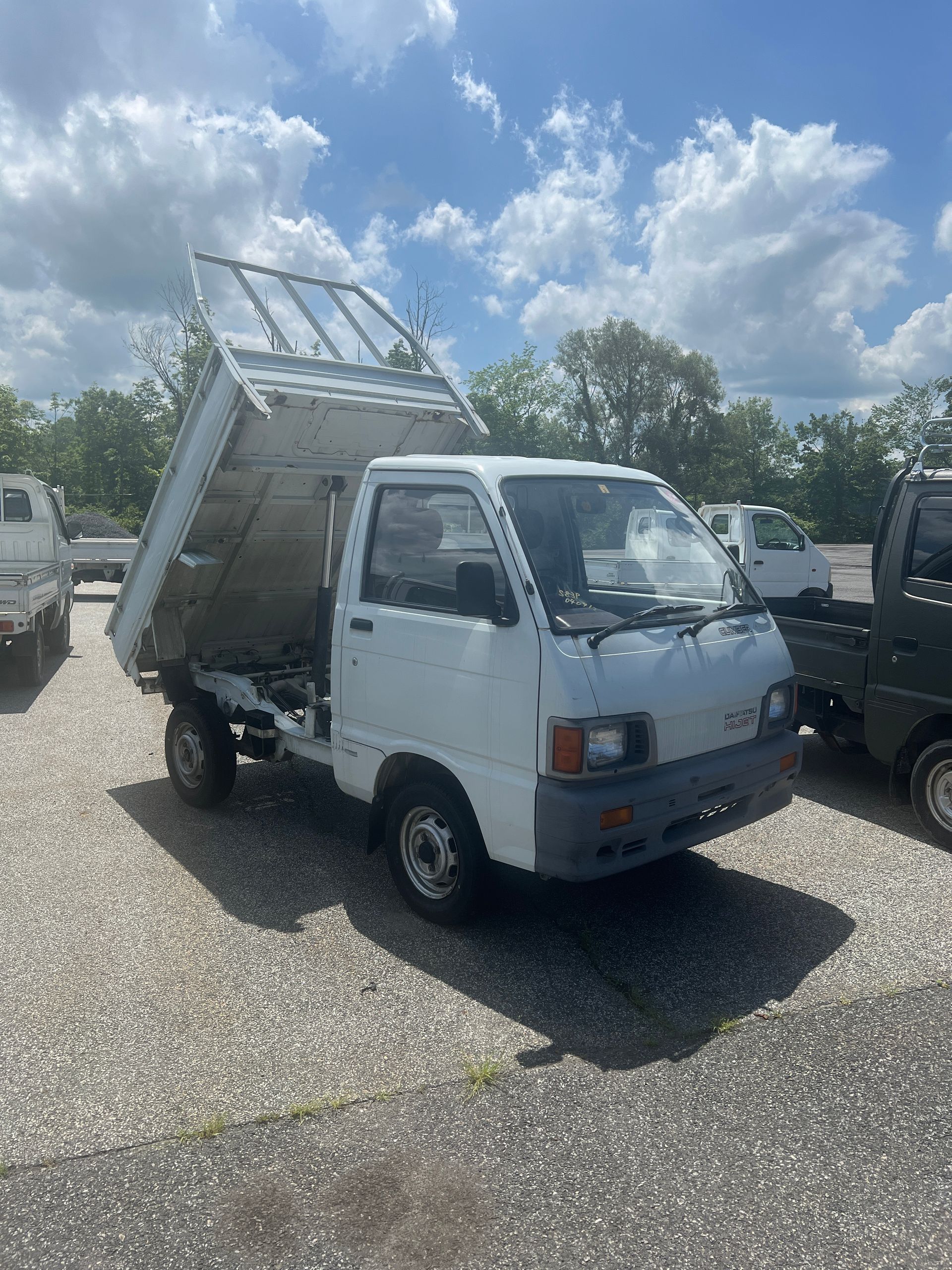 A white dump truck is parked in a gravel lot