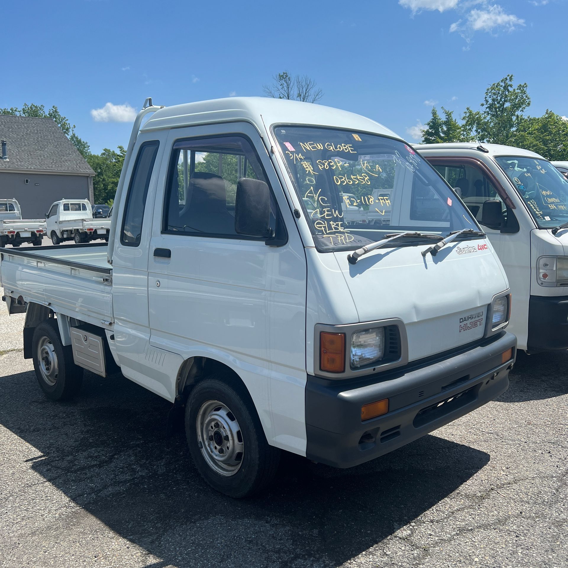 Two white trucks are parked next to each other in a parking lot