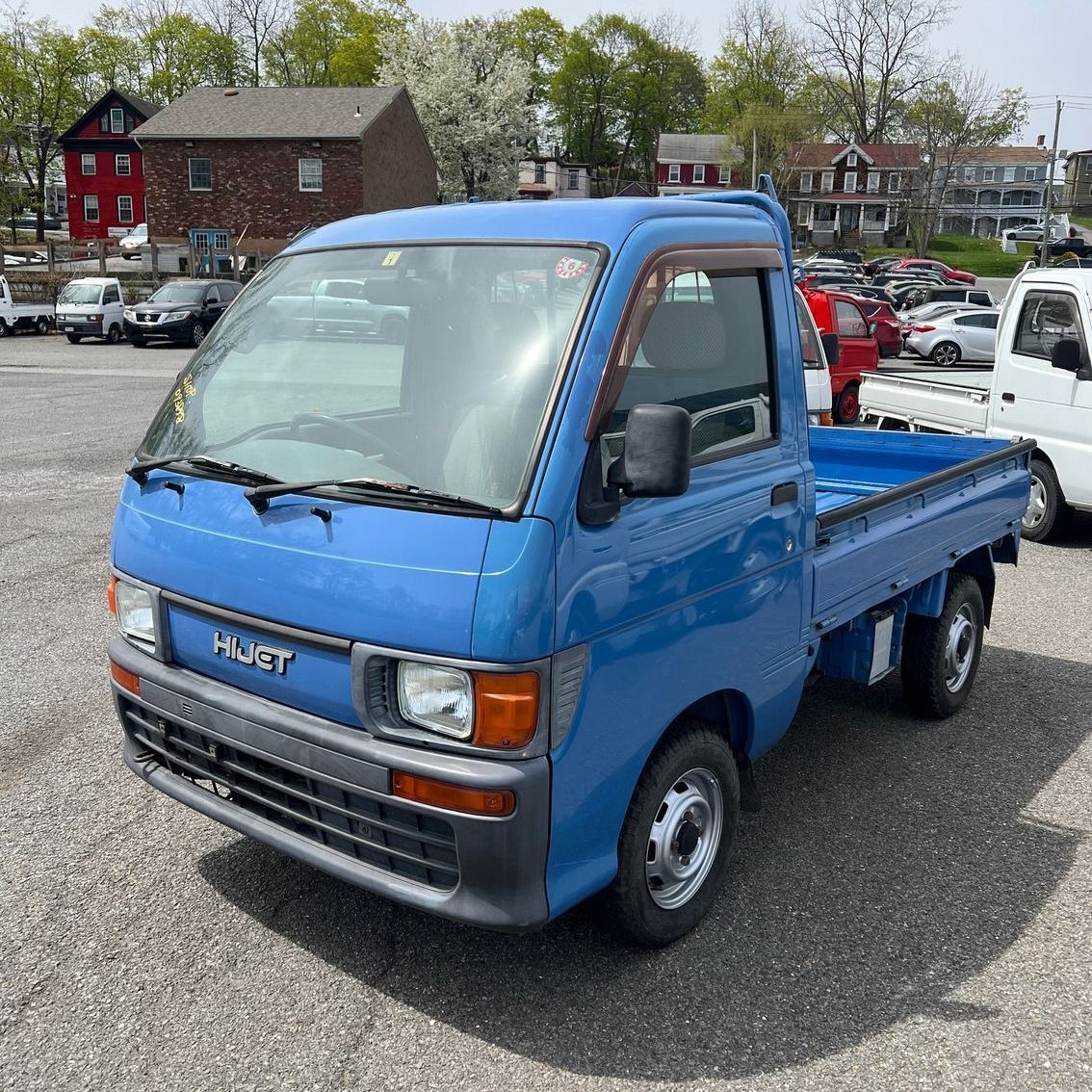 A blue pickup truck is parked in a parking lot.