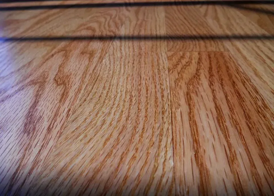 Close-up view of light brown wood flooring with prominent grain patterns.