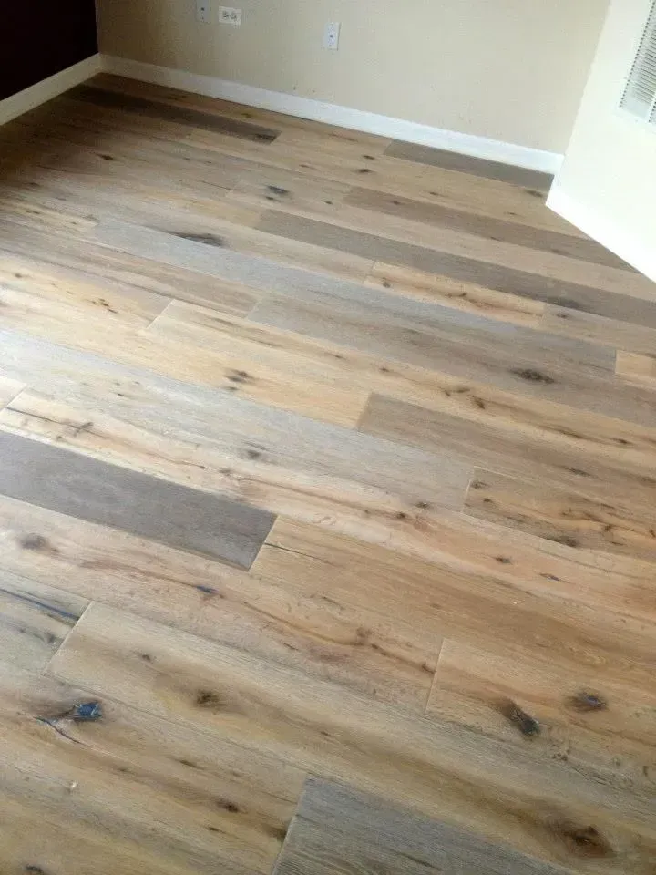 Light oak hardwood flooring with visible natural wood grain and knots, installed in an interior room.