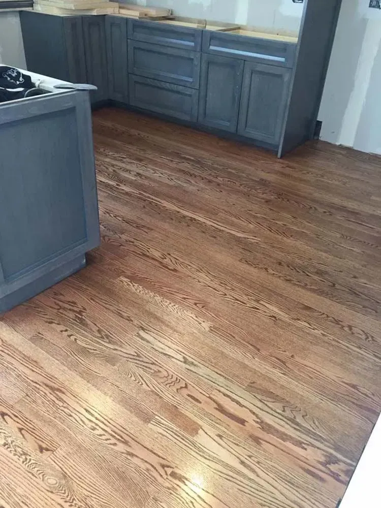 A kitchen featuring blue-grey cabinetry and light-colored, wood-grain plank flooring.
