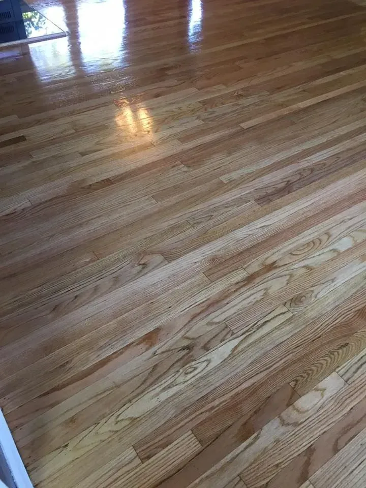 Polished light-toned hardwood floor planks with visible wood grain running horizontally.