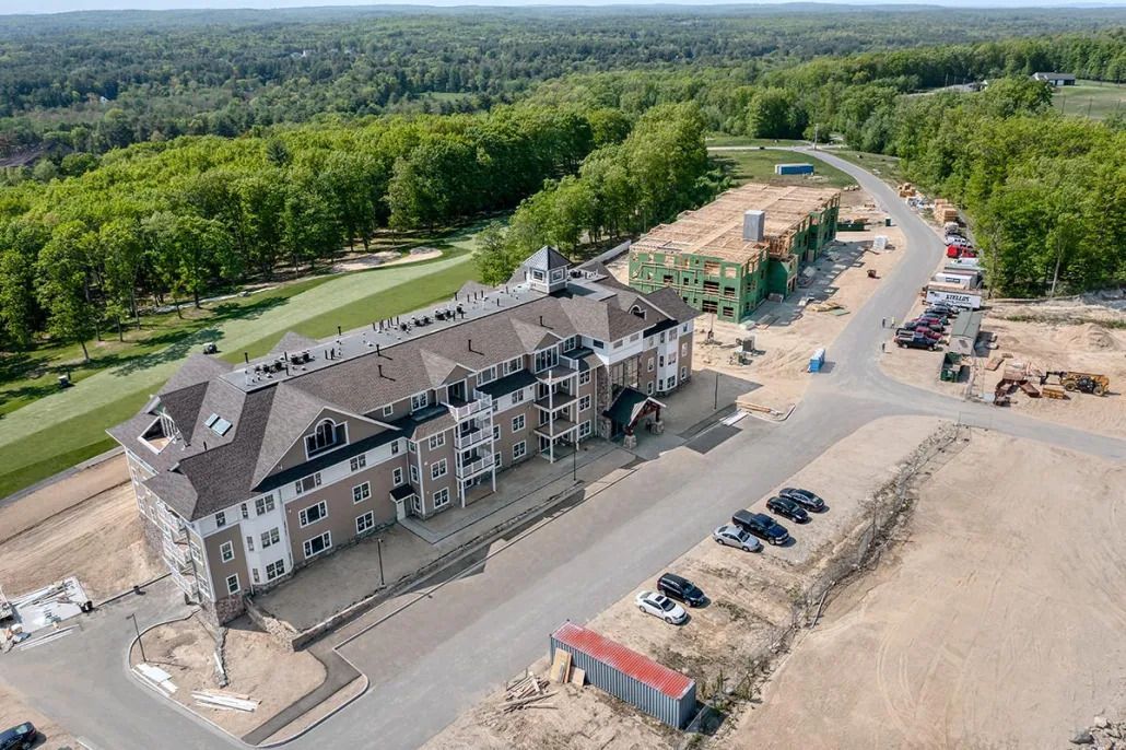 An aerial view of a building under construction in the middle of a forest.