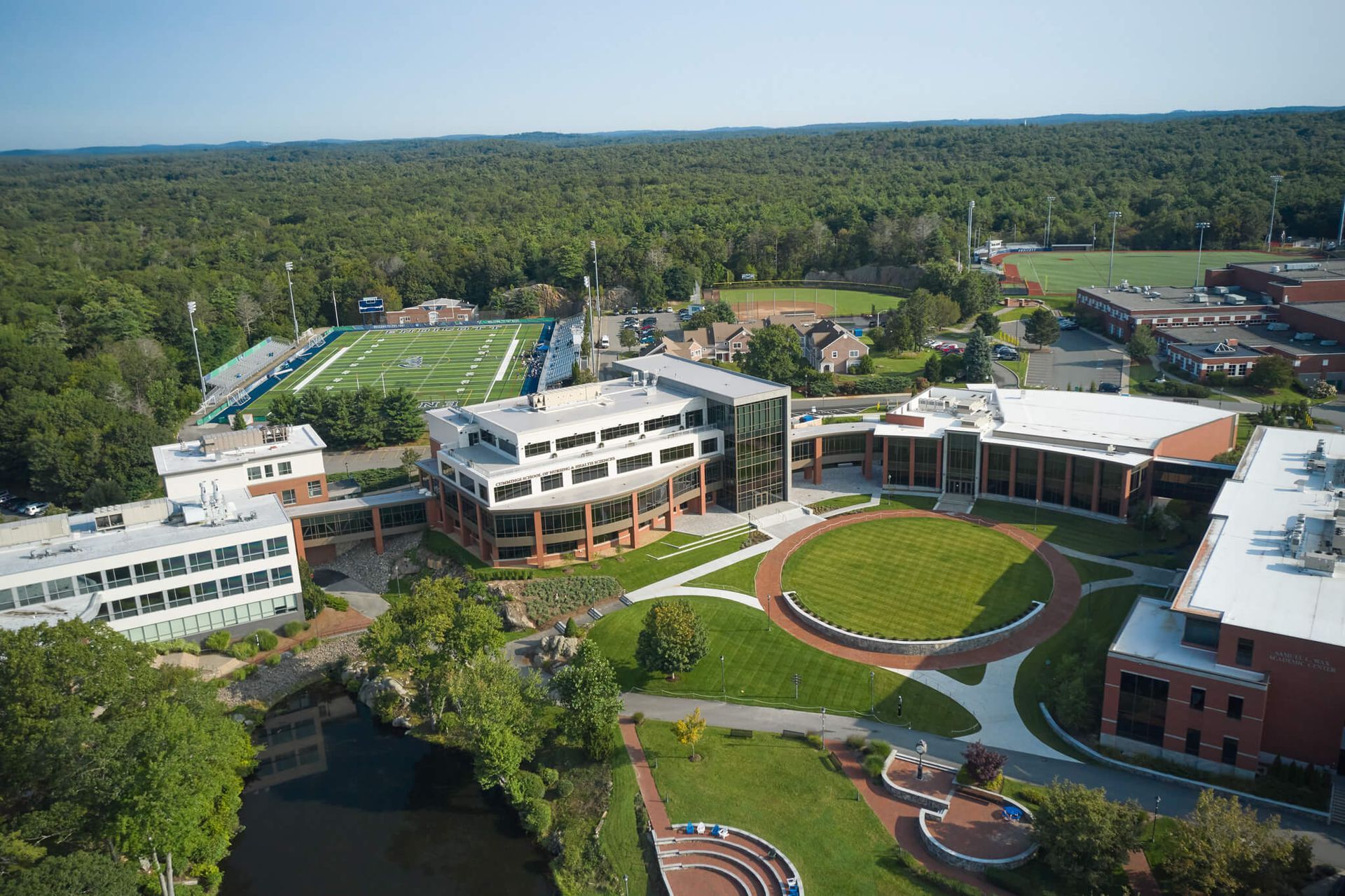 An aerial view of a college campus with a lake in the middle.