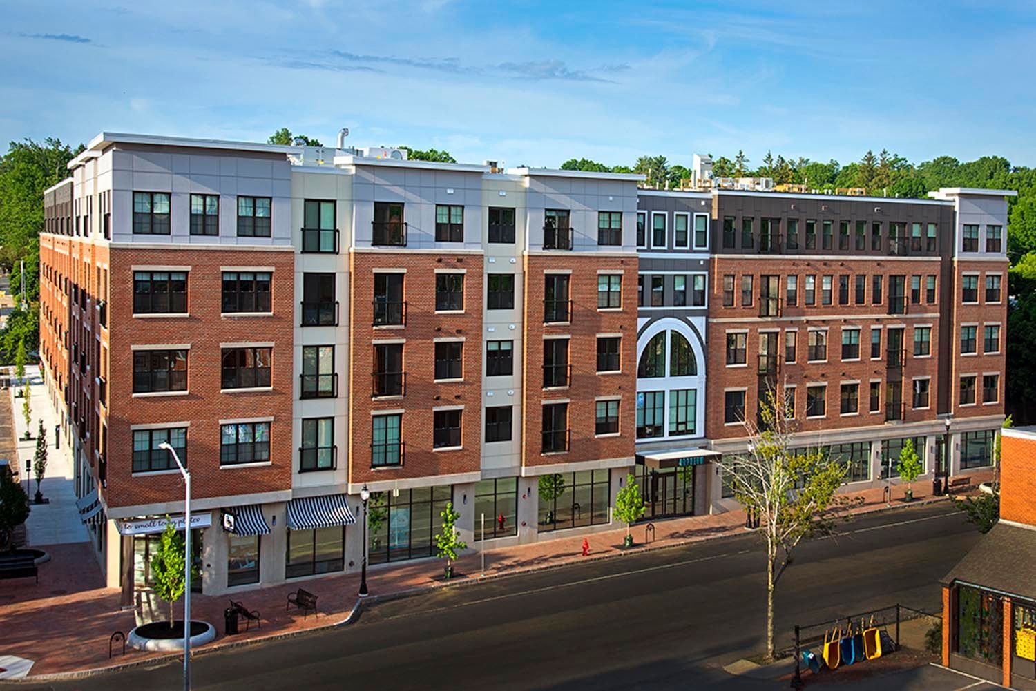An aerial view of a large brick building next to a street.