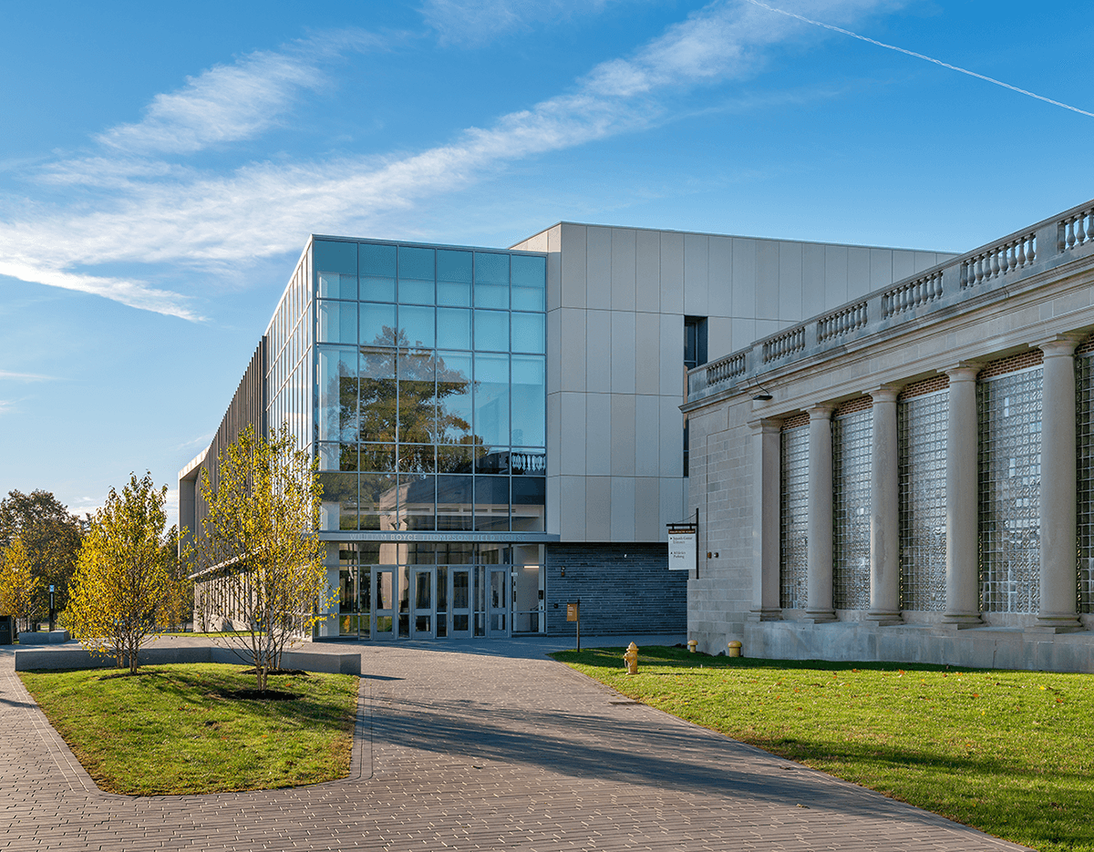 A large building with a lot of windows and columns on a sunny day.